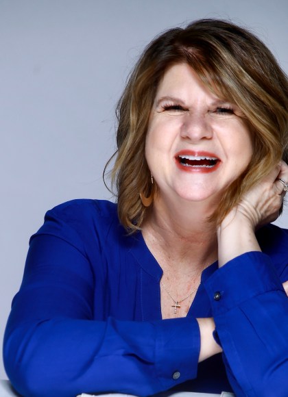 author photo of woman author laughing in blue shirt