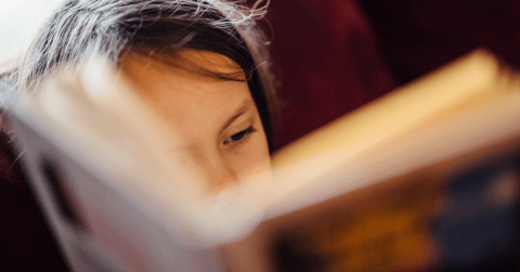 children reading a book close up