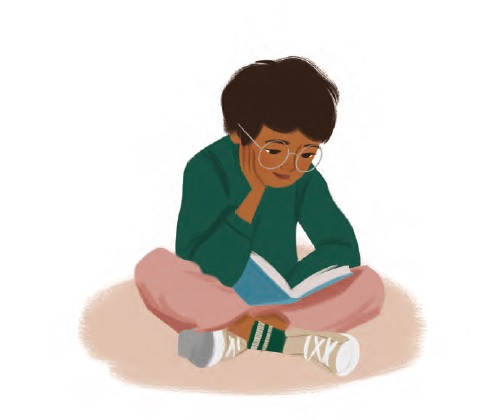a boy sitting cross-legged reading a book