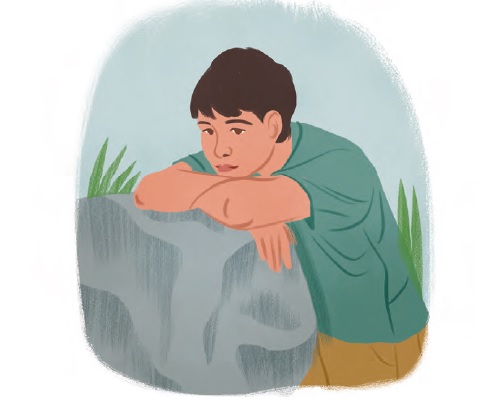 a boy sitting next to a boulder looking thoughtful
