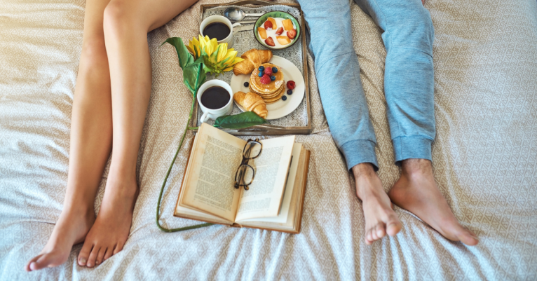 couple in bed with food and books