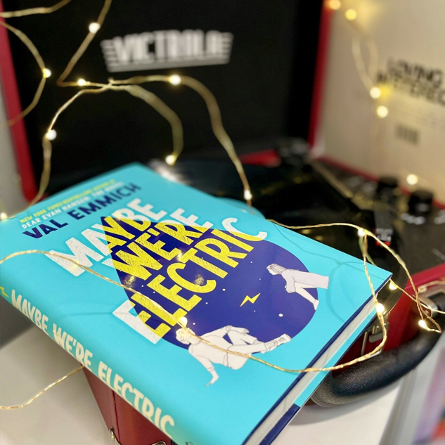 NOVL - Instagram image of book cover for 'Maybe We're Electric' by Val Emmich set on a record player with twinkle lights