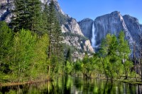 main stream at Yosemite Falls in Yosemite National Park with a reflective Merced River in the foreground.