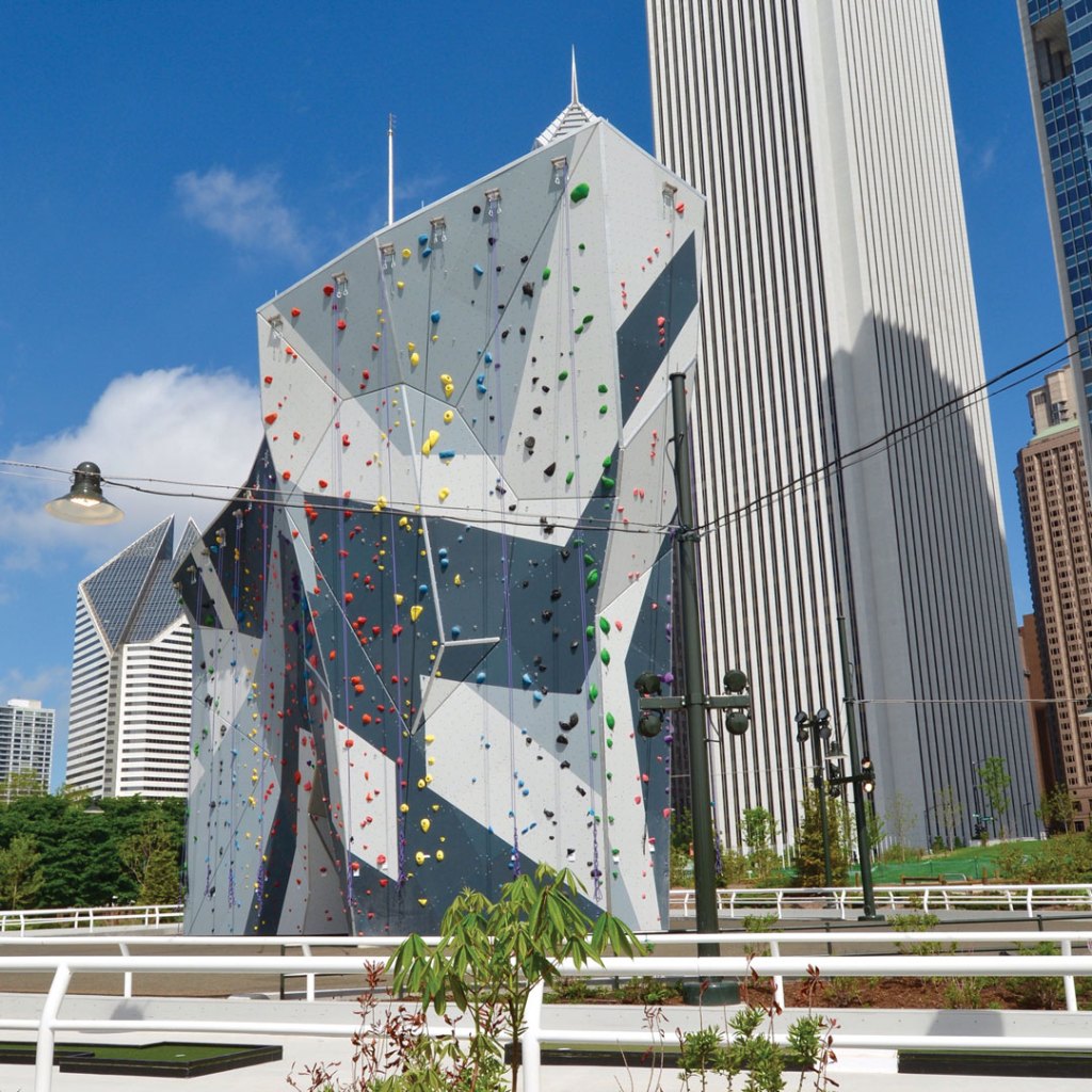 climbing wall built in an abstract shape with highrise buildings in the distance