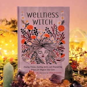 Lifestyle photo of "Wellness Witch" surrounded by flowers, crystals, and glowing lights