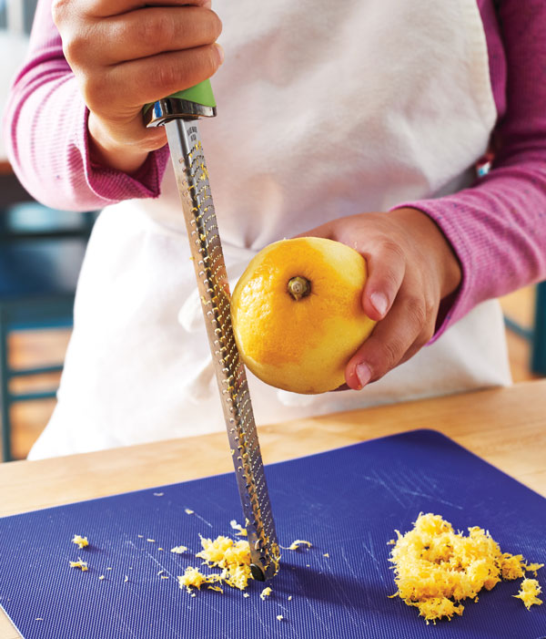 Photo of hands zesting a lemon.