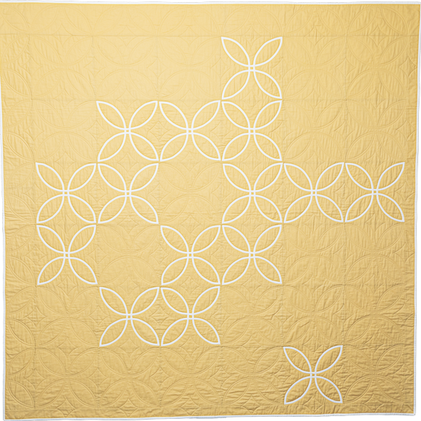 Photo of a pale yellow quilt.