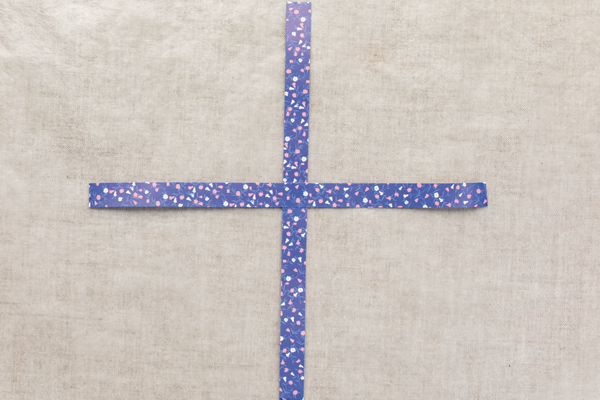 Photo of two paper strips laid in a cross.