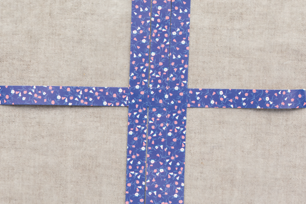 Photo of four strips of colored paper woven in a cross.