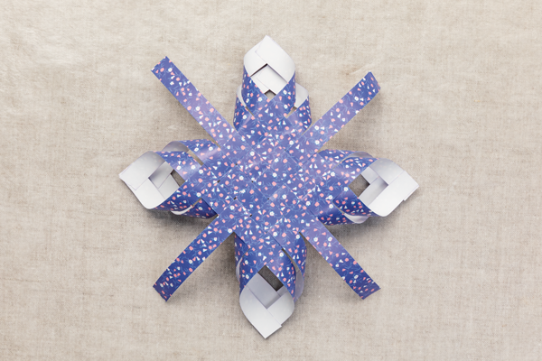 Photo of a partially completed paper star made out of colored paper.