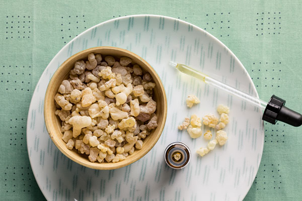 Photo of frankincense and oil dropper on a plate.