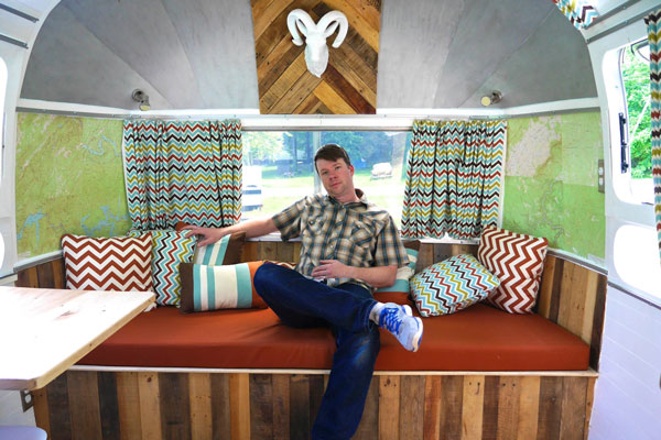 Photo of author Derek "Deek" Diedricksen sitting on a bench in an Airstream Overlander.