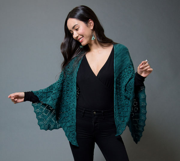 Photo of a woman wearing a deep teal knit shawl.