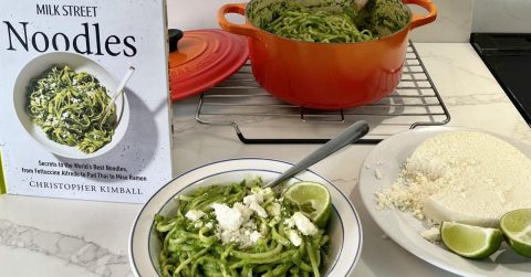 Photo of a bowl of pasta next to the book MILK STREET NOODLES