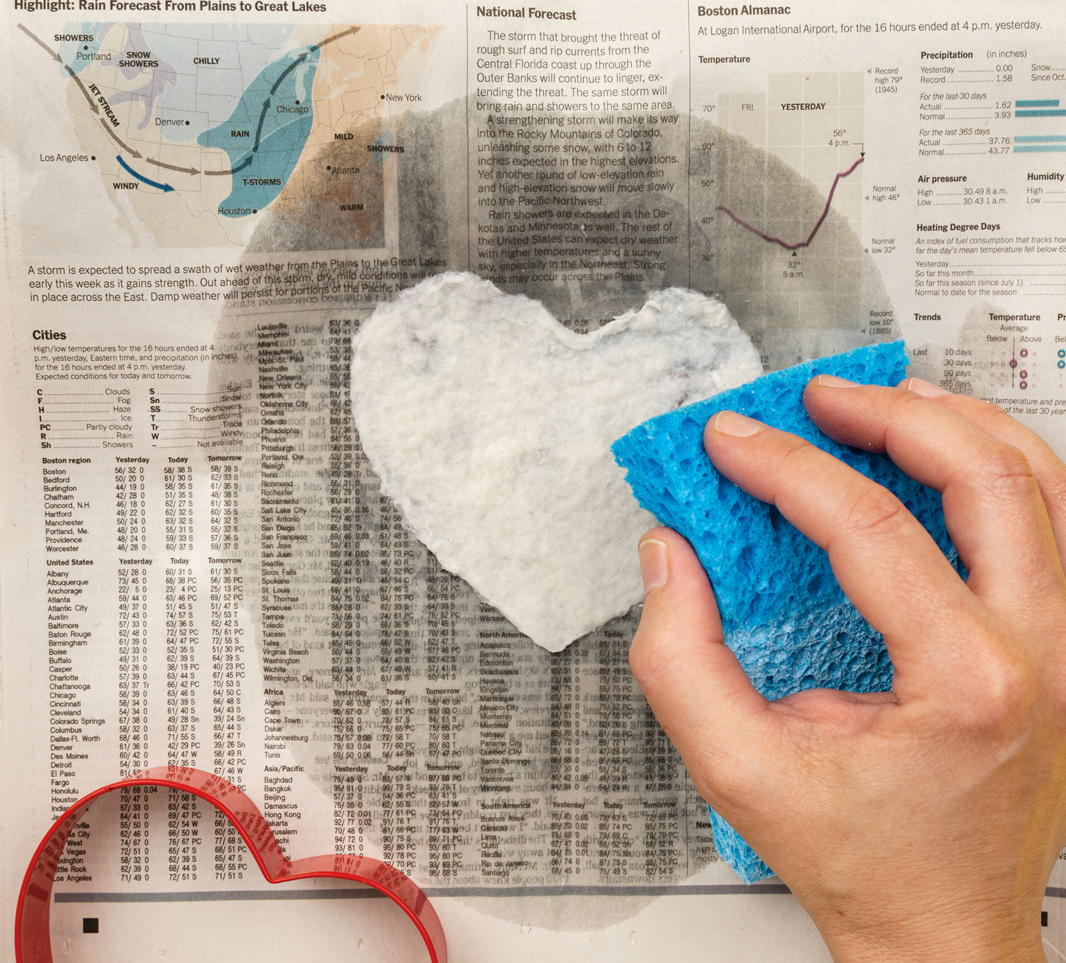 Photo of hand using sponge to press water out of heart-shaped plantable paper.