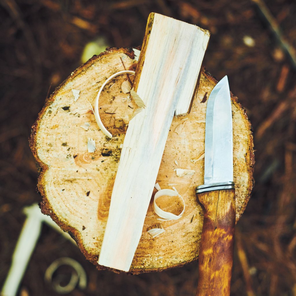 Photo of piece of wood and knife on log.