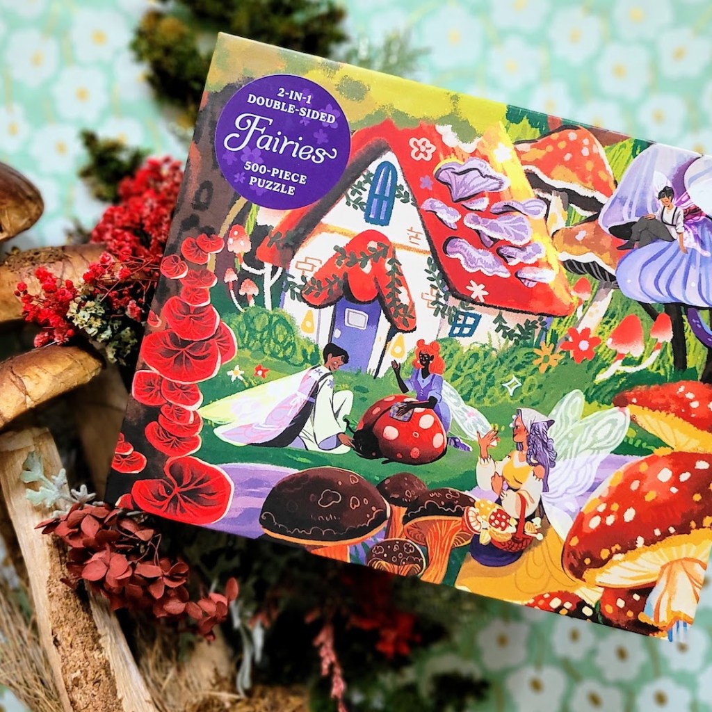 Photo of the Fairies 2-in-1 Double-Sided 500-Piece Puzzle surrounded by mushroom figurines and decor
