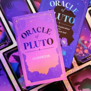 Photo of the guidebook laid above the keepsake box and various face-up cards from "Oracle of Pluto: A 55-Card Exploration of the Undiscovered Self"