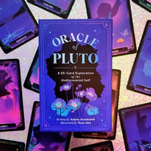 Photo of the keepsake box of "Oracle of Pluto: a 55-Card Exploration of the Undiscovered Self" laid above various face-up cards from the deck