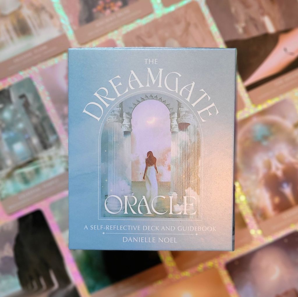 Photo of “The Dreamgate Oracle: A Self-Reflective Deck and Guidebook” keepsake box laid above face-up cards from the deck