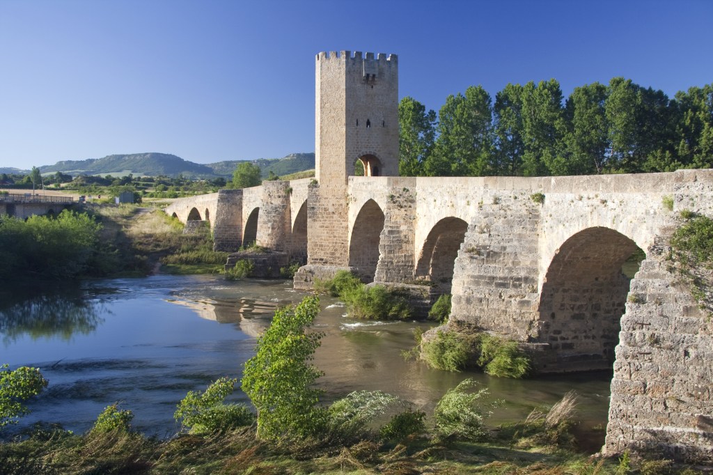 An ancient arched stone bridge crossing a river