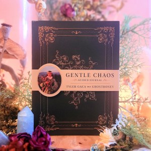Photo of "Gentle Chaos Guided Journal" standing among floral decor with a soft pink backlight