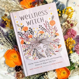 Photo of "Wellness Witch" laid above a bouquet of flowers