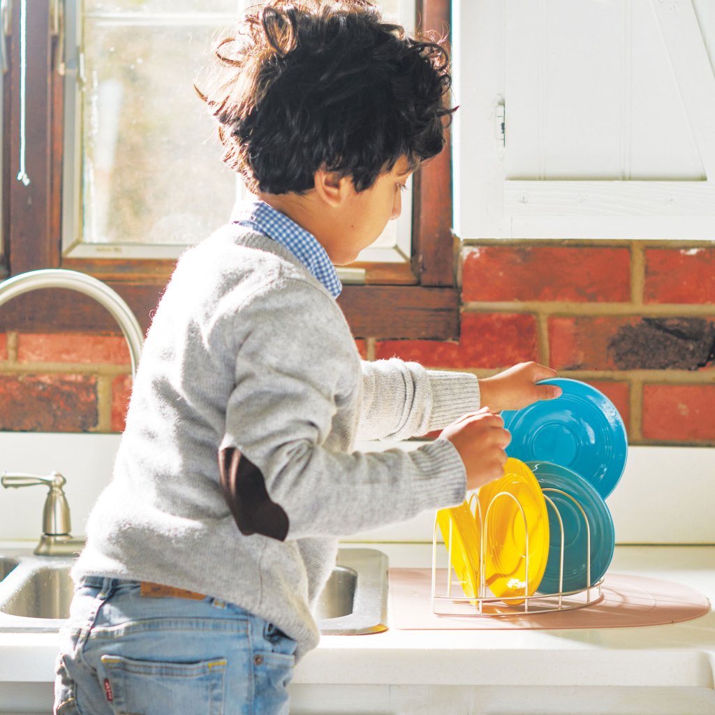 Photo of a child washing dishes.
