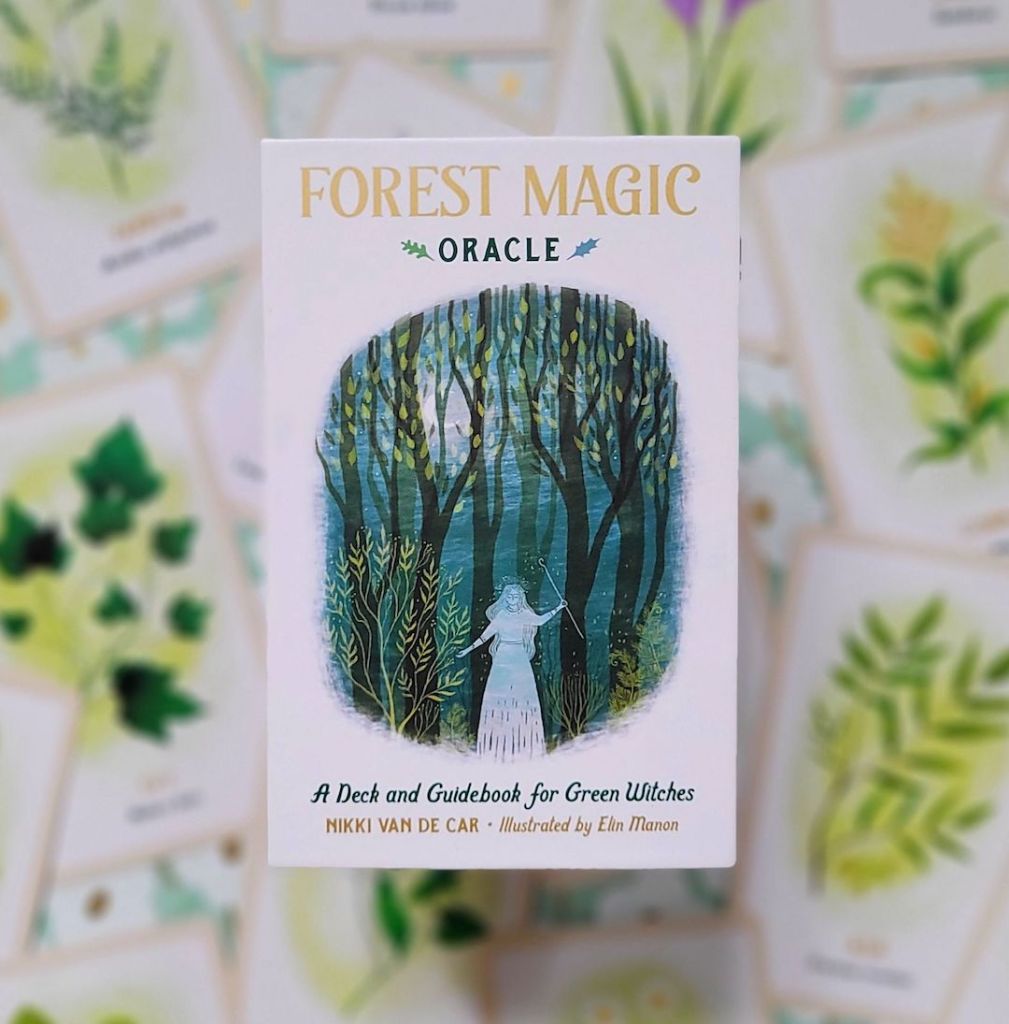 Photo of “Forest Magic Oracle: A Deck and Guidebook for Green Witches” laid above face-up cards from the deck