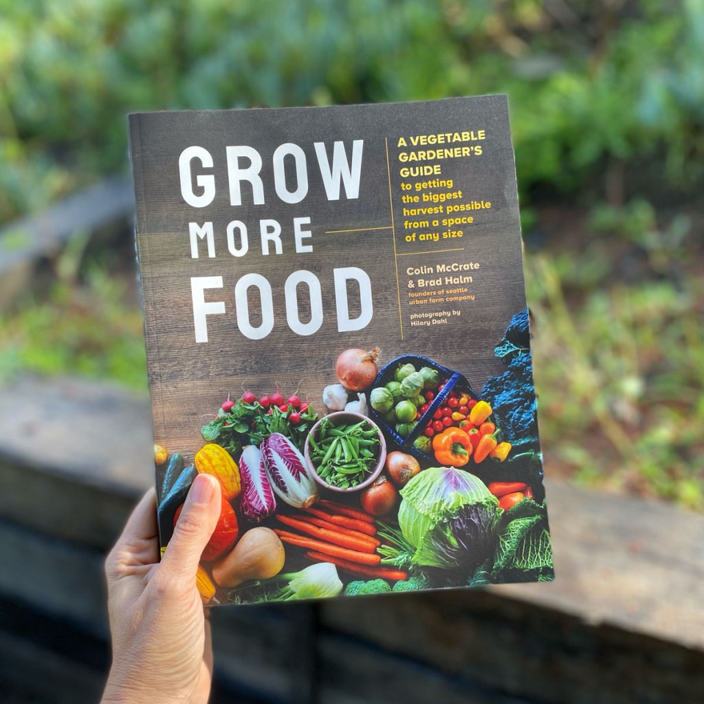 Grow More Food book cover in a garden setting.