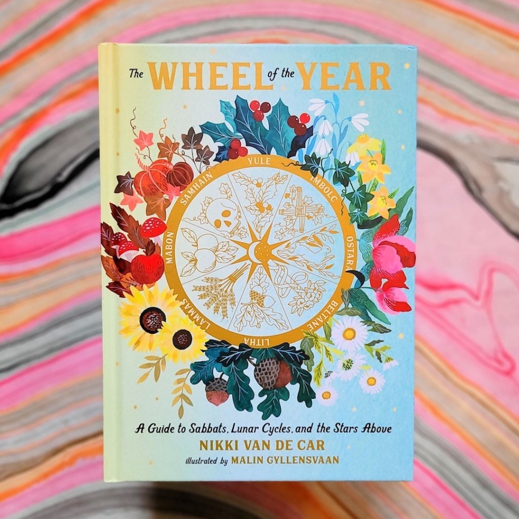 Photo of The Wheel of the Year laid above a colorful marbled backdrop
