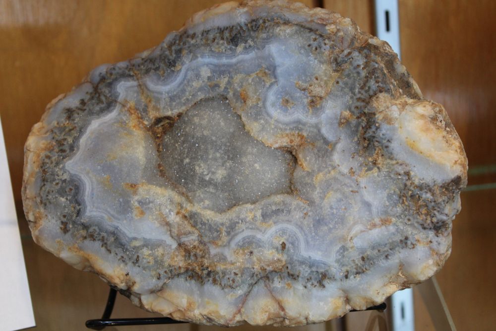a big piece of tan and blue rock bisected down the middle on display in a museum