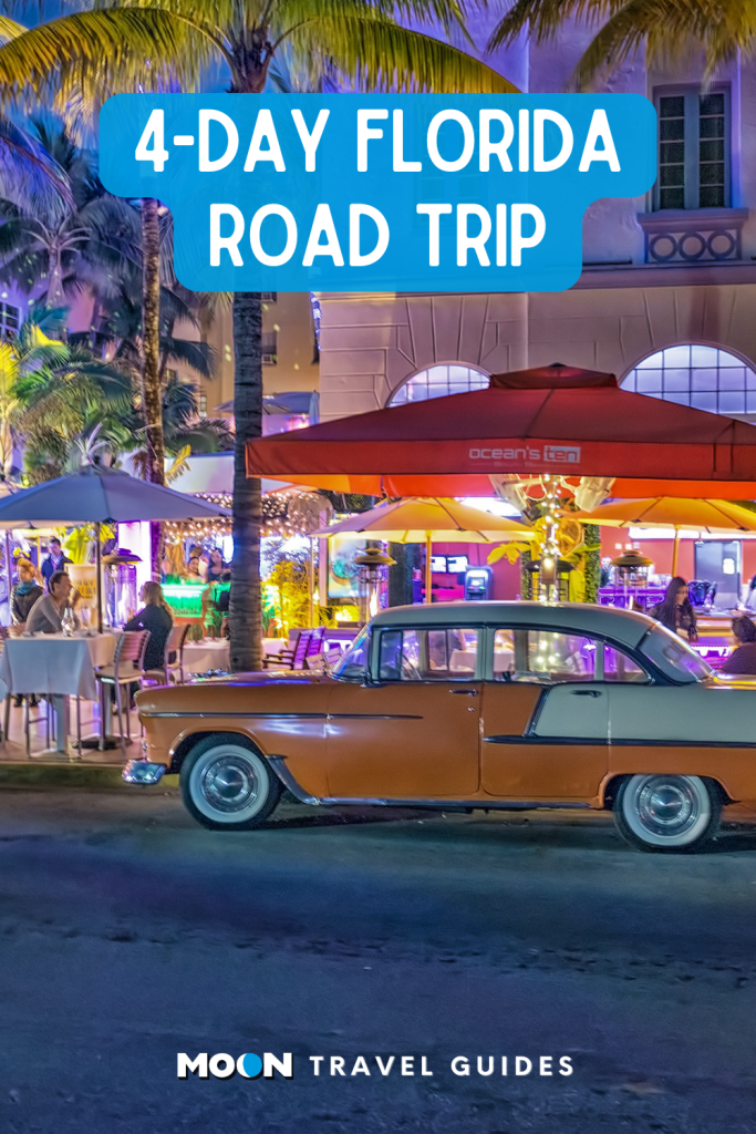 a vintage car parked on the curb of miami beach at night with palm trees and bar tables lit by neon lights