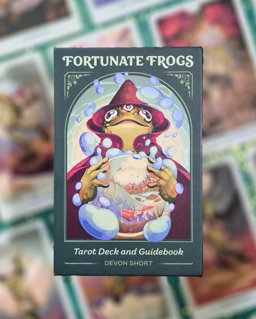 Photo of the Fortunate Frogs box laid above cards from the deck