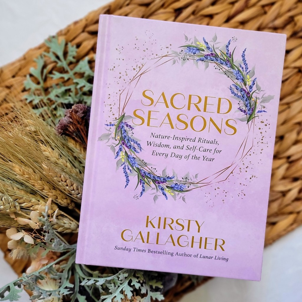 Photo of Sacred Seasons laid on a woven mat with floral decor