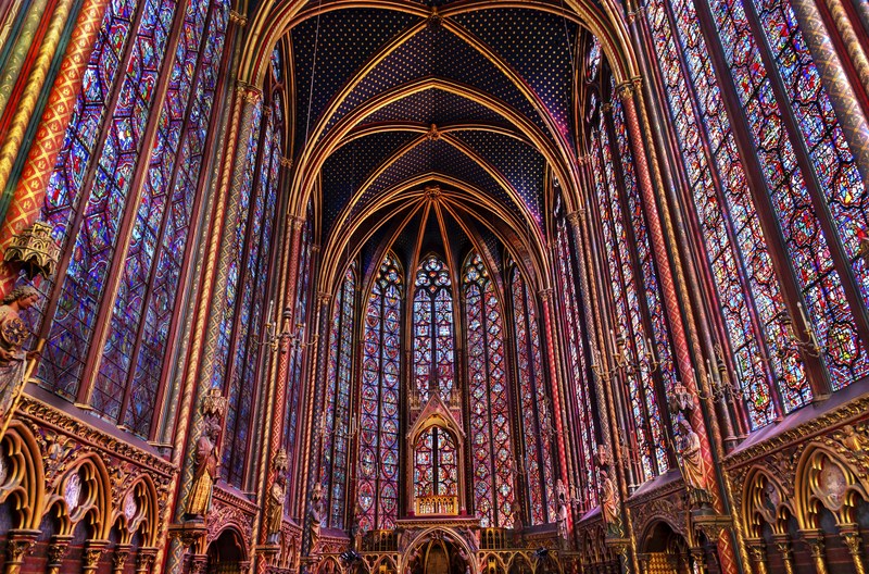 Image of vaulted church nave lined with intricate, colorful stained glass windows