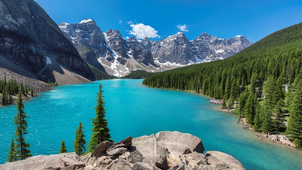 Beautiful turquoise waters of the Moraine Lake with snow-covered peaks above it in Rocky Mountains, Banff National Park, Canada.