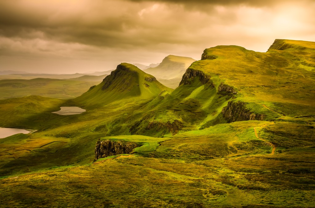 dusky mist covering the bright green rolling hills of the scottish highlands