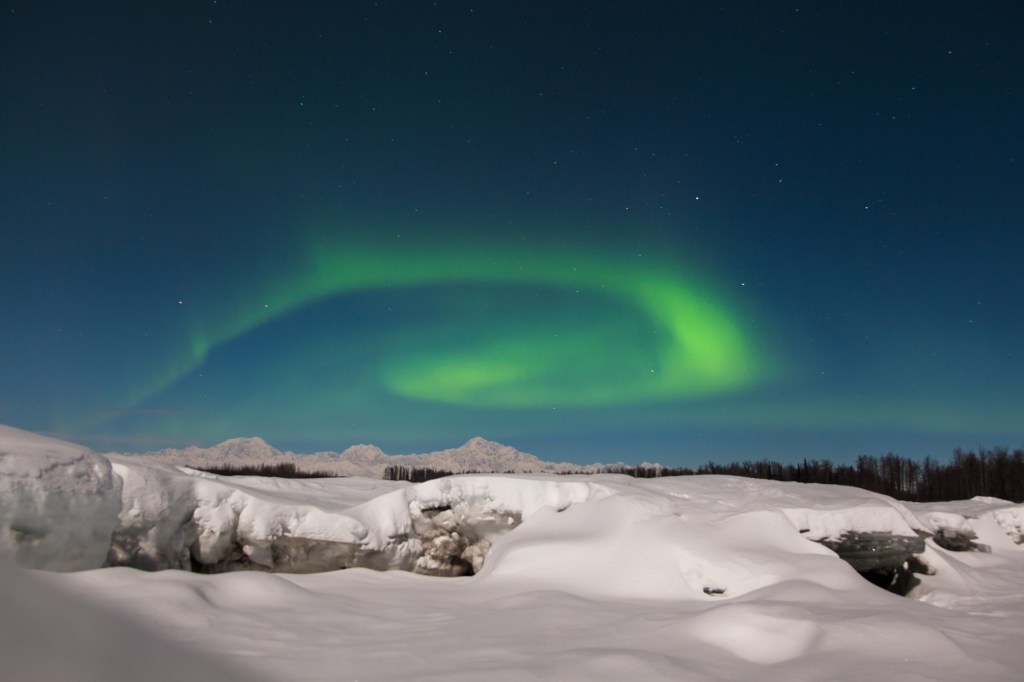 Northern lights over snowy mountains